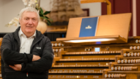 Dirk Koudijs die voor een groot orgel van Johannus zit